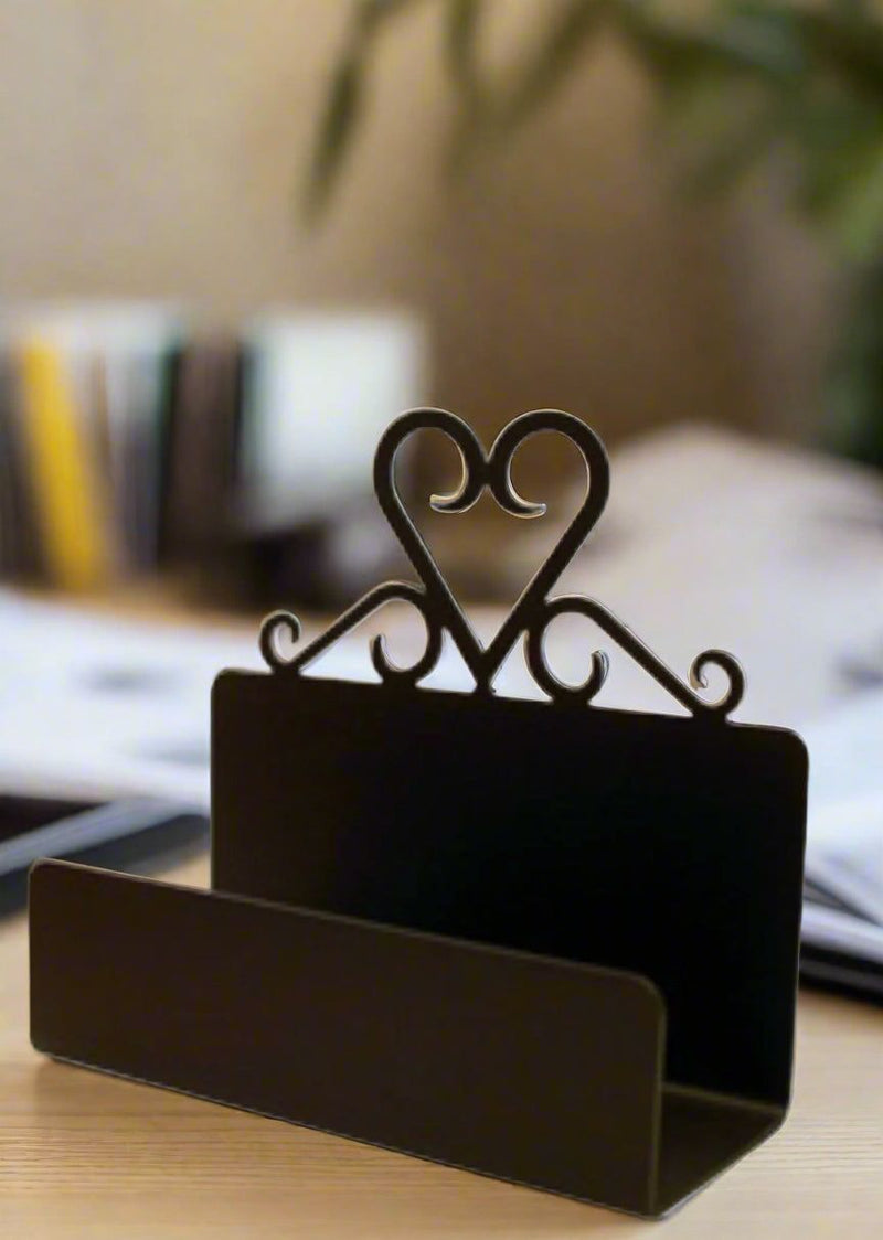 Black Heart Business Card Holder on a desk, featuring elegant heart scrollwork, perfect for stylish office organization and card display.