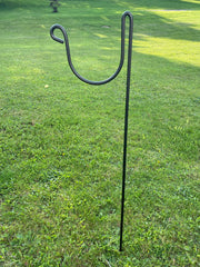 Hose Holder Round Large staked into grassy lawn, showcasing durable metal design for outdoor garden hose organization and storage.