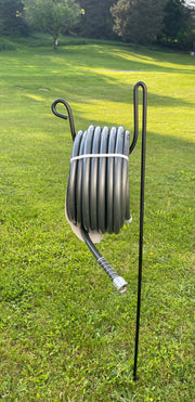 Hose Holder Round Large supporting a heavy-duty hose in a green lawn, designed for outdoor hose storage and easy access in gardens.