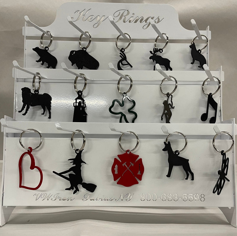 Key Chain Closeout & Free Display featuring assorted novelty keychains including animals, symbols, and themed shapes on a white metal rack.