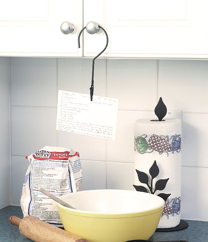 Cabinet-mounted hanger holder for recipe cards in a kitchen setup, keeping instructions visible above a mixing bowl and baking tools.