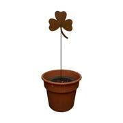 Shamrock Rusted Garden Stake displayed in a terracotta pot, perfect for adding festive flair to patios or garden planters.