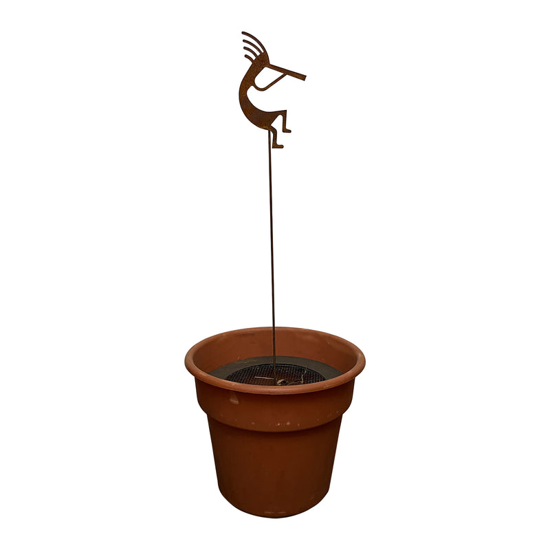 Kokopelli rusted garden stake displayed in a planter pot, showcasing its decorative use in patios and gardens.