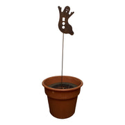 Rusted ghost garden stake displayed in a flower pot, showcasing rustic Halloween decor for outdoor garden or patio settings.