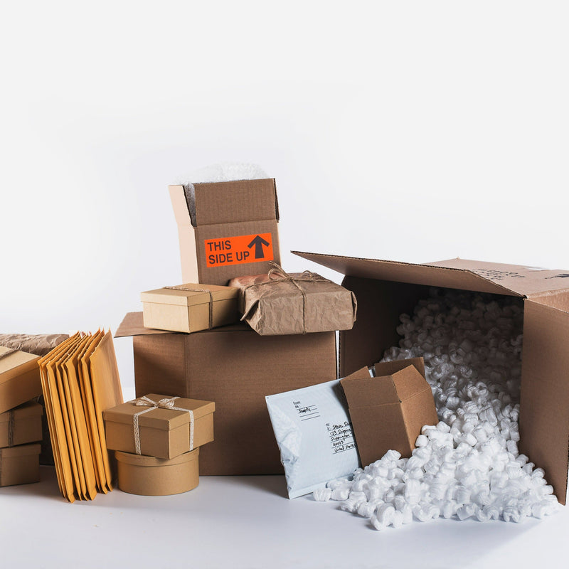 Assorted shipping supplies including boxes, padded envelopes, and packing peanuts for Dropship Handling Fee-DO NOT REMOVE in office shipping category.