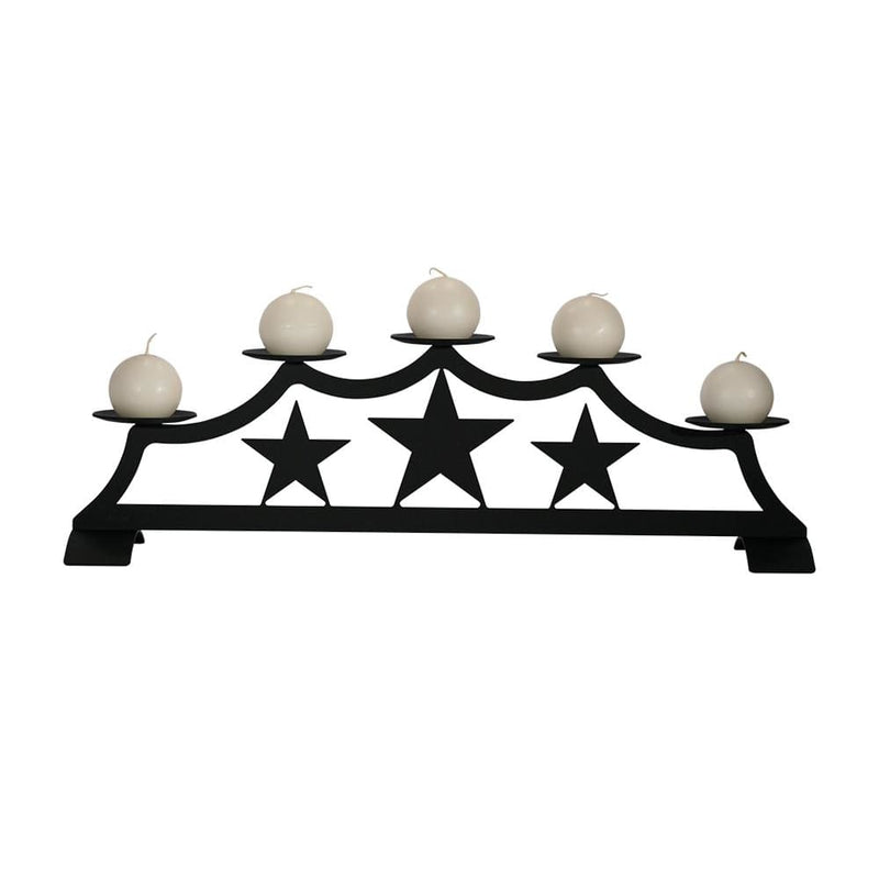 Star Fireplace Pillar Candle Holder with five round white candles on a black metal stand featuring three decorative stars, ideal for hearth decor.